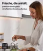 Frau in einer Küche, die Gewürze aus einem quadratischen Glas mit Bambusdeckel zu einer Schüssel Salat hinzufügt, mit einem Gewürzregal im Hintergrund Produktbild-Vorschau
