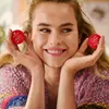 A woman is holding two coffee capsules in her hands, smiling. Anteprima dell’immagine prodotto