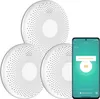 Three white circular CO detectors are arranged in a cluster, with a smartphone displaying a CO alarm notification next to them. Produktbild-Vorschau