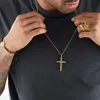 A person wearing jewelry, including a gold cross necklace and a gold skull ring. Náhľad obrázku produktu