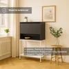 A dark gray secretary desk with a white frame and shelf, placed in a room with a window, radiator, and a wooden stool. There are plants and a framed picture on the wall. Produktbild-Vorschau