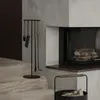 A fireplace set with tools and a log basket next to a fireplace. Anteprima dell’immagine prodotto