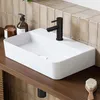 A white ceramic basin with a black faucet is shown on a wooden shelf, with tiled walls in the background. Anteprima dell’immagine prodotto