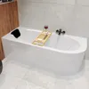A modern bathroom with a white bathtub, a wooden bath tray with soap, a glass of red wine, and a black bath pillow.