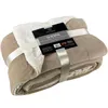 A folded beige sherpa blanket with a cream-colored sherpa lining, tied with a ribbon and a product tag. Náhled obrázku produktu