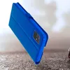 A blue flip cover for a Samsung Galaxy A71 phone is shown at an angle against a textured surface and a blurred background. Podgląd zdjęcia produktu