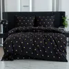 A bed with black bedding featuring a gold heart pattern. Produktbild-Vorschau