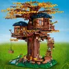 A detailed LEGO model of a treehouse with multiple levels and figures, set against a grassy field and blue sky. Produktbild-Vorschau
