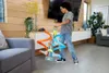 A young boy is playing with a toy car track set in a living room. Anteprima dell’immagine prodotto