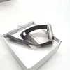 A smartwatch with a gray band is placed inside a white box, with the box lid open. Podgląd zdjęcia produktu