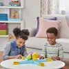 Two children are playing a board game on a table in a living room. Produktbild-Vorschau