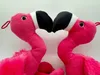 Close-up of two pink plush flamingo toys with their beaks touching. Produktbild-Vorschau