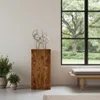 A modern living room with a wooden pedestal displaying a sculpture, plants, and a large window overlooking a garden. Voir les images du produit