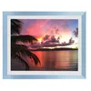 A framed picture of a sunset over the ocean with palm fronds in the foreground. Produktbild-Vorschau
