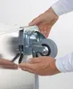 Hands attaching a caster wheel to a metal box. Produktbild-Vorschau