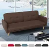 A brown sofa is shown in a room with a large window overlooking the ocean. Anteprima dell’immagine prodotto