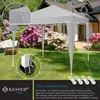 A gray pop-up pavilion set up in a garden with flowering bushes and a house in the background. Produktbild-Vorschau