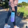 A person walking outdoors holding a large water bottle. Produktbild-Vorschau
