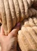 A hand is shown touching a textured fabric. Produktbild-Vorschau