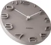 A close-up, angled view of a wall clock with raised numbers and white hands. Anteprima dell’immagine prodotto