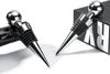 Two chrome bottle stoppers are shown, one inserted into a wine bottle and the other resting on a black box. Produktbild-Vorschau