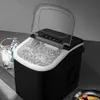 A black and white ice maker filled with ice, with a clear lid open, next to a bucket of ice and bottles. Náhled obrázku produktu