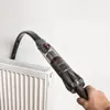 A hand is using a handheld vacuum cleaner to clean a radiator. Produktbild-Vorschau