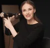 A woman is using a hairdryer to style her hair. Podgląd zdjęcia produktu