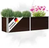 A dark brown planter box with silver trim, filled with green plants and pink flowers. A white banner with the German flag and text "DESIGNED IN GERMANY" is attached to the front. Produktbild-Vorschau