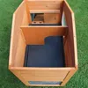 An overhead view of an empty wooden animal hutch with a black plastic tray. Produktbild-Vorschau