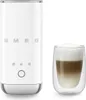 A white Smeg milk frother and a glass of frothed milk. Voir les images du produit
