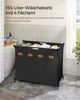 A black laundry basket with four compartments is shown in a bathroom setting, next to a bathtub and a window. Produktbild-Vorschau