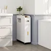 A white slim storage cabinet with a drawer and open shelves is placed in a bathroom next to a white cabinet and a bathtub. Náhľad obrázku produktu