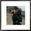 A couple kissing outdoors, with the man holding the woman. The image is framed. Produktbild-Vorschau