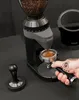 A close-up shot of a coffee grinder with coffee beans in the hopper and ground coffee in the portafilter. Podgląd zdjęcia produktu