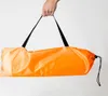 A hand holding an orange bag with black straps. Náhled obrázku produktu