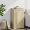 A wooden cabinet is placed next to a sofa and a basket of laundry. Anteprima dell’immagine prodotto