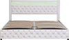 A white upholstered bed frame with a slatted base and green LED lighting. Produktbild-Vorschau