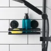A black metal shower shelf with suction cups holding a teal soap dispenser and a yellow sponge, mounted on a white tiled wall. Podgląd zdjęcia produktu