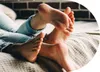 Two people's feet are intertwined on a bed. Podgląd zdjęcia produktu