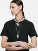 A woman wearing a black t-shirt and multiple pieces of Swarovski jewelry, including necklaces, earrings, and bracelets. Produktbild-Vorschau