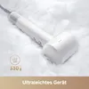 A white hairdryer is placed on a bed of white feathers, with text overlays indicating its features. Produktbild-Vorschau
