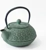 A green cast iron teapot with a black handle is shown against a white background. Podgląd zdjęcia produktu