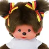 Close-up of a Monchhichi doll wearing a white shirt and bows in its hair decorated with the German flag colors. Náhled obrázku produktu
