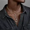 A person wearing a denim shirt is shown wearing multiple layered necklaces. Náhled obrázku produktu