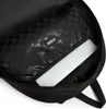 Close-up view of the inside of a black backpack, showing a laptop sleeve and the checkered lining. Náhľad obrázku produktu