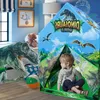 A young boy sits inside a dinosaur-themed play tent in a child's bedroom. Podgląd zdjęcia produktu