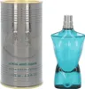 A bottle of Jean Paul Gaultier Le Male aftershave lotion and its cylindrical packaging are displayed side-by-side on a white background. Voir les images du produit
