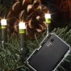 Close-up of LED lights on pine needles with a pine cone in the background and a remote control in the foreground. Produktbild-Vorschau