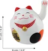 A white Maneki-neko cat figurine with red and gold accents, shown from the front. Produktbild-Vorschau